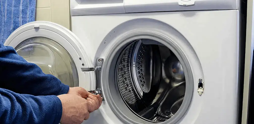 Washing machine repair handyman checking a front-load washer door and latch in Lakewood, CO