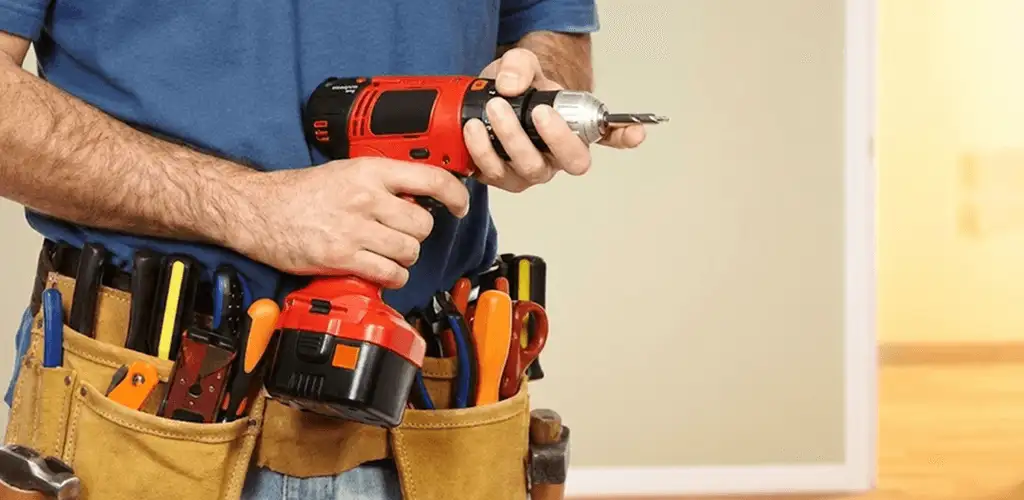 Handyman holding a power drill for home repairs and installations in Lakewood, CO