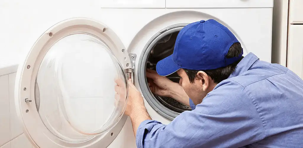 Washing machine repair handyman inspecting a front-load washer drum in Lakewood, CO