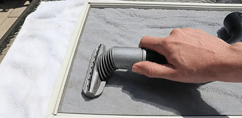 Window screen repair cleaning and fixing a damaged screen mesh in Lakewood, CO